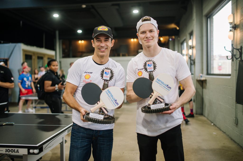 Josef Newgarden stands with fellow Celebrity Ping Pong Challenge champion in 2019