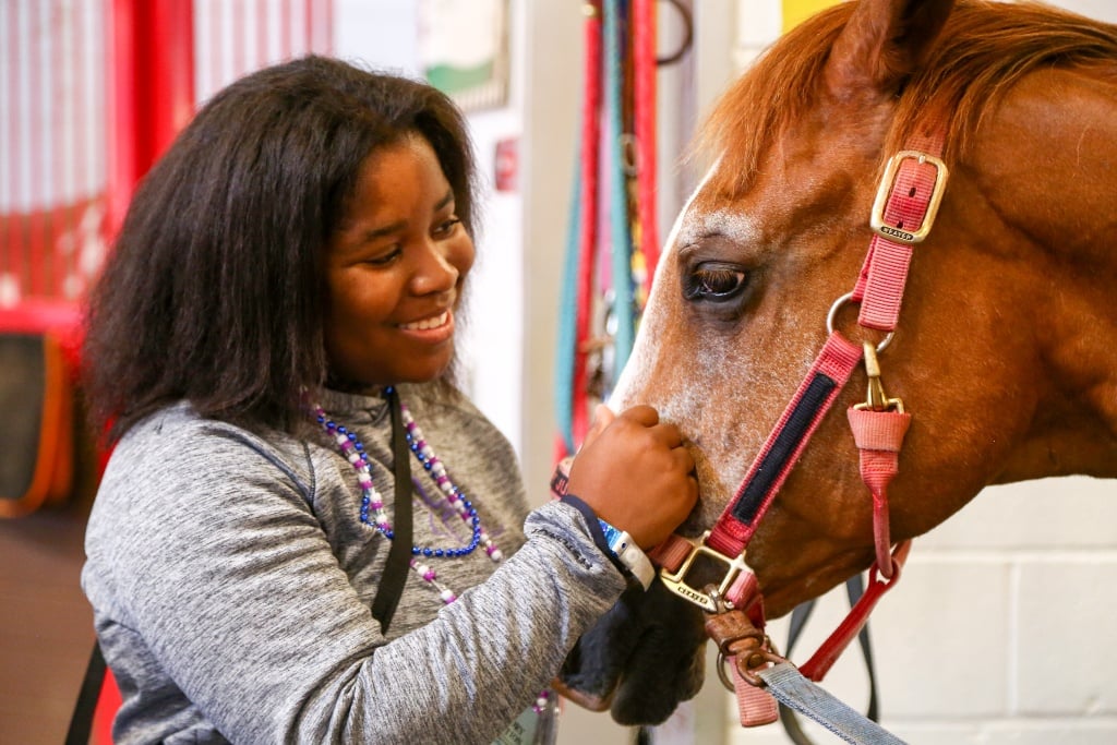 A camper looking lovingly at a horse at Victory Junction, the SeriousFun camp in North Carolina