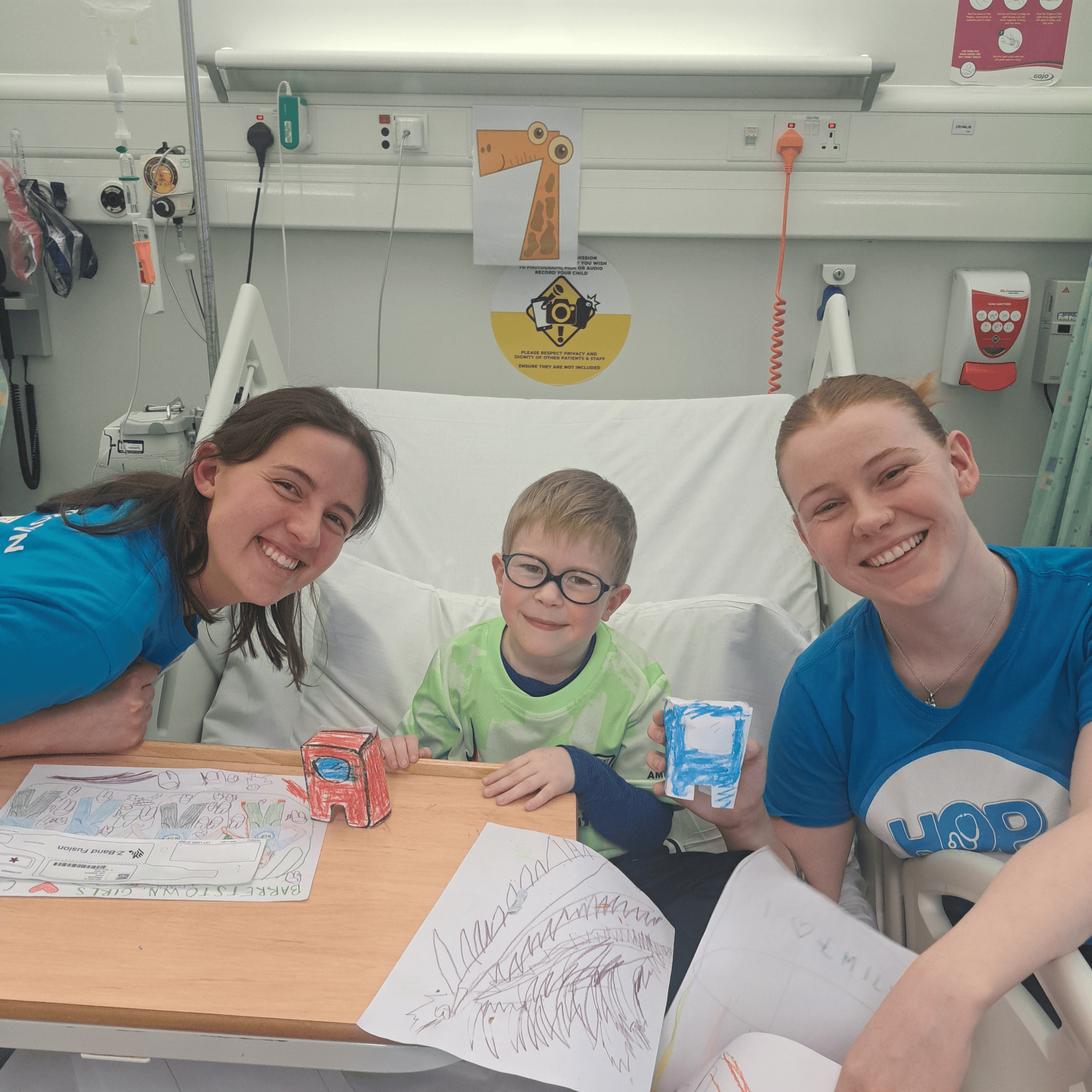 Two Barretstown camp counselors with a camper during a hospital camp program